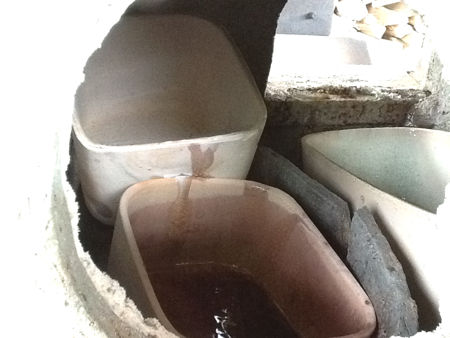 A pot containing white glass piled on top of a pot containing purple glass