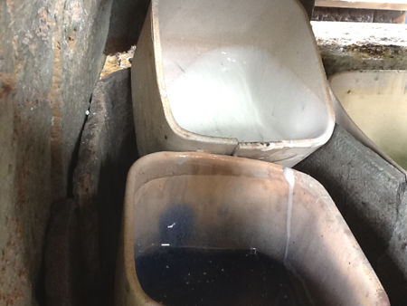 A pot containing white glass piled on top of a pot containing cobalt blue glass