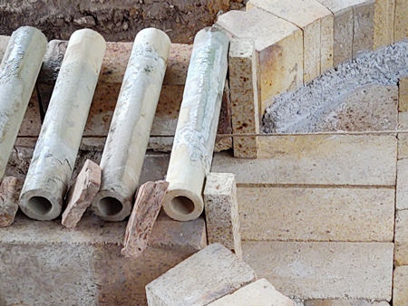 Detail showing the two sillimanite brick offcuts acting as stops for the first firebar. These will be concreted in position.